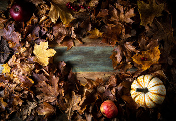 
Background with yellow dry autumn foliage and pumpkin on a wooden table