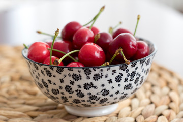 Fresh red cherries in bowl on wooden white table