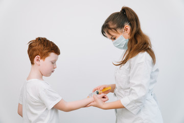 Obraz na płótnie Canvas Doctor injecting a child with a vaccination in a small disposable hypodermic syringe, close up of the kids arm and needle