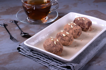 Kartoshka cake on the ceramic platter on the grey wooden table. Russian potato-shaped dessert