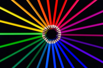 pencils folded in a color circle on a black background