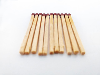 Perspective view of Piles of brown matchstick isolated on white. Wooden rods with a flammable head used to light a fire.