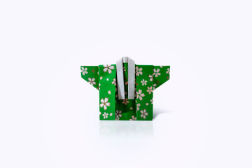 Handcrafted isolated Japanese green kimono paper origami on white background with reflection	