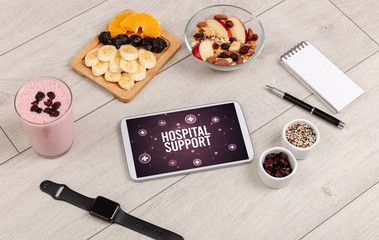 HOSPITAL SUPPORT concept in tablet pc with healthy food around, top view