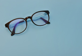 Black and blue Glasses on blue Background.Glasses frame made from rubber.