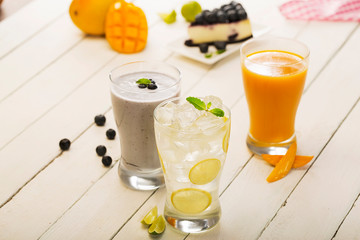 assortment of fresh iced fruit drinks on wooden background