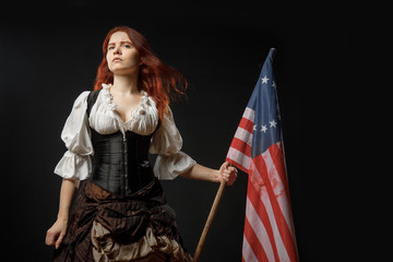 Girl in historic dress from United States Revolutionary War with flag. July 4th, Independence Day USA Concept Photo Composition