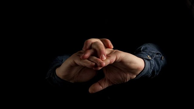 men's hands interlace and stretch their fingers. on a black background