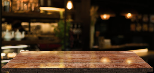 Empty old wood table top with bokeh coffee shop interior background.