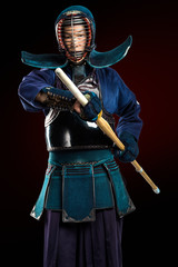 Portrait of man kendo fighter with shinai (bamboo sword). Shot in studio. Isolated with clipping...