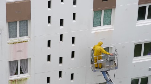 Homme utilisant un nettoyeur haute pression sur une nacelle