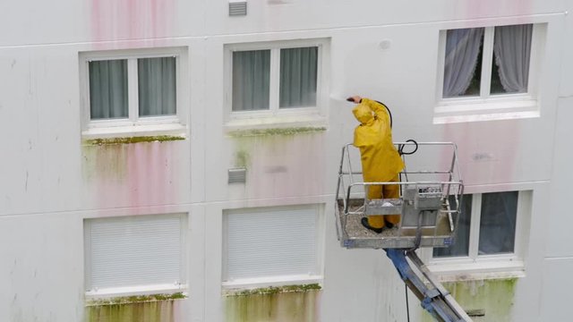 Homme utilisant un nettoyeur haute pression sur une nacelle