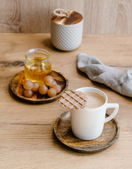 Healthy snack set with muscat grapes, honey and coffee with waffles on wooden background. 