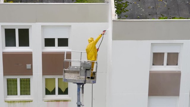Homme utilisant un nettoyeur haute pression sur une nacelle