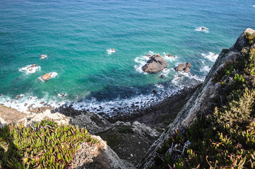 View of the ocean from the Stone Mountain down in the blue water. Waves breaking to the rock