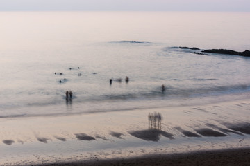 Obraz premium People taking their last swim at sunset on Zumaia beach