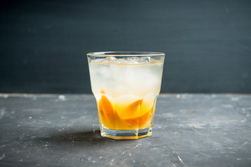 Old fashioned beverage with orange slices on rustic background. Selective focus. Shallow depth of field.
