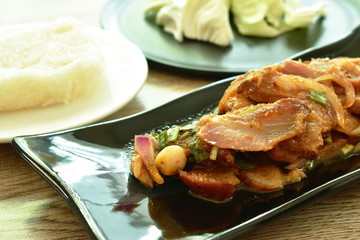 spicy roasted pork Thai salad eat with fresh cabbage and sticky rice on plate