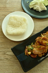 spicy roasted pork Thai salad eat with fresh cabbage and sticky rice on plate