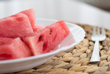 Slices of watermelon on a plate on white table