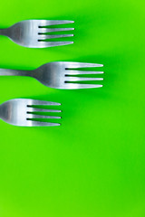 cutlery on green background flat lay