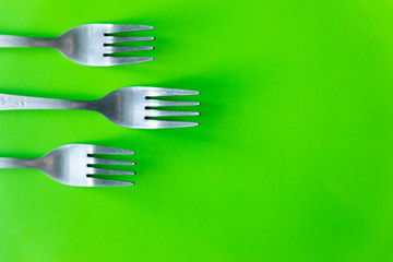 cutlery on green background flat lay