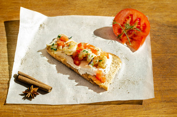 baguette with seafood tomato and cinnamon wooden cutboard background