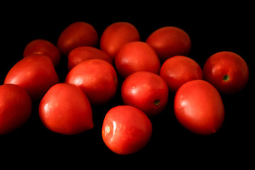 Red ripe tomatoes on black background. Top view with copy space
