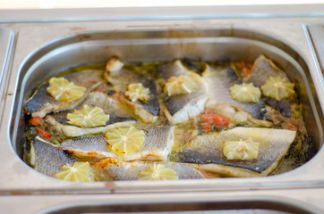 bass fish with lemon inside pan