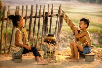 Fotobehang Rural children playing with blowing music and laughter. People Thailand. © Thirawatana