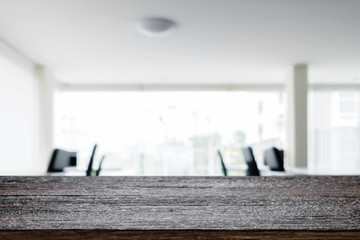 Desk space over blurred office or meeting room background. Product display.