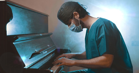 Il medico pianista suona al pianoforte con la mascherina