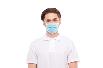 A man in a white T-shirt of European appearance in a medical mask. Covid 19 virus protection.