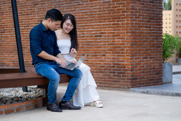 Happy young couple of travellers on vacation sightseeing city with laptop computer.