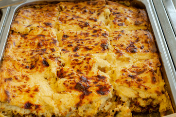 a container holding hot water into which a pan is placed for slow cooking pasticcio