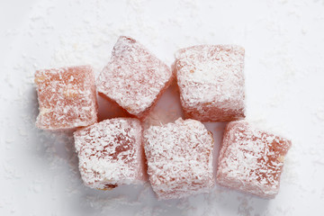 Turkish delight cubes with coconut flakes isolated on white background. Turkish sweets