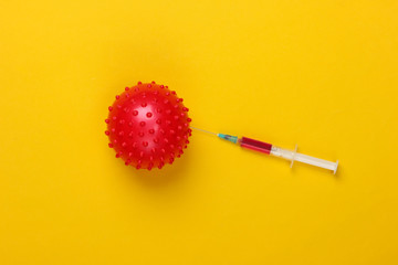 Coronavirus vaccine. Virus strain and syringe on yellow background. Vaccination. Medical concept. Pandemic