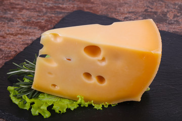 Maasdam cheese  in the board served salad leaves