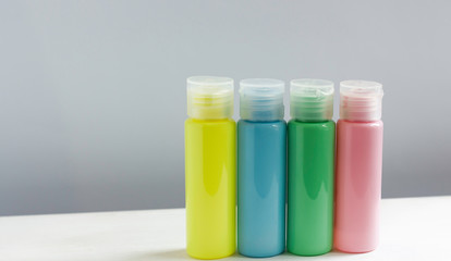 Isolated spa cosmetic products, multicolored tubes, branding mockup, side view on gray background