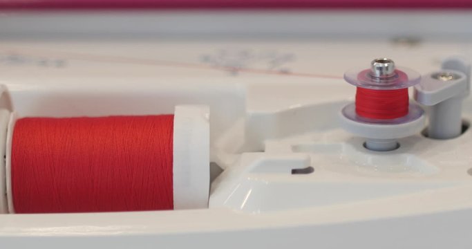 Spinning clews with threads on rack at a textile plant. Thread is Wound on a Robbin. Close-up of a Spool with Thin Thread on Working Vintage Sewing Machine. Spool with thin cotton white thread.