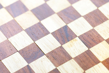 Chess board background. Handmade chessboard assembled from pieces of different wood