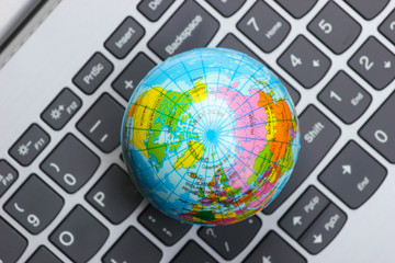 Global network. Globe on a laptop keyboard closeup. Online communication