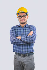 Young engineer asian man wearing long sleeve striped shirts with arms crossed and yellow hard hat