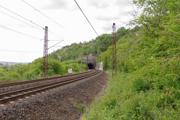 Obraz na płótnie Canvas tracks for trains leading through the countryside and a dark old tunnel
