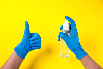 Hands in medical gloves holding bottle with antiseptic spray. Medicine and healthcare concept