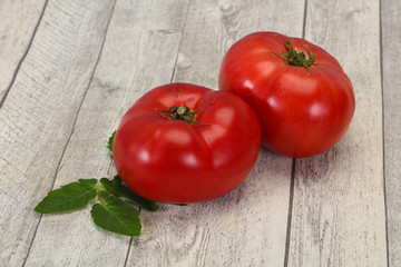 Ripe tomato over wooden background