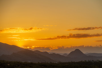 The sun setting behind mountains in the Sonoran Desert of Arizona.
