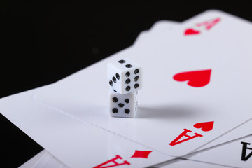 Two dice with aces on a black background with reflection