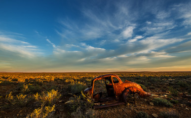 Very old car wreck in Karoo, South Africa with wispy clouds