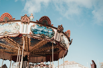 Children carousel at a fair under blue sky in Europe.